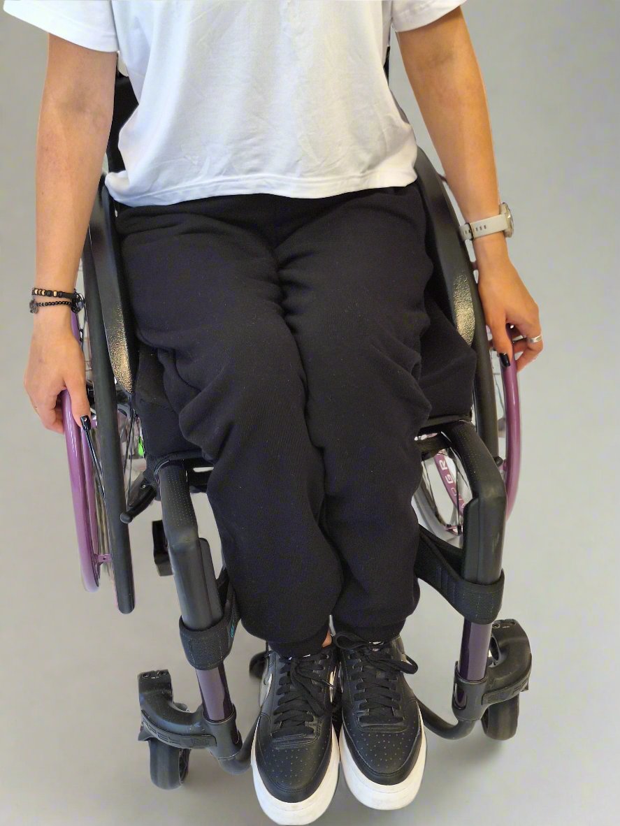 Girl in a wheelchair dressed in Vilber's woman's jersey wheelchair adaptive pants and white adaptive t-shirt