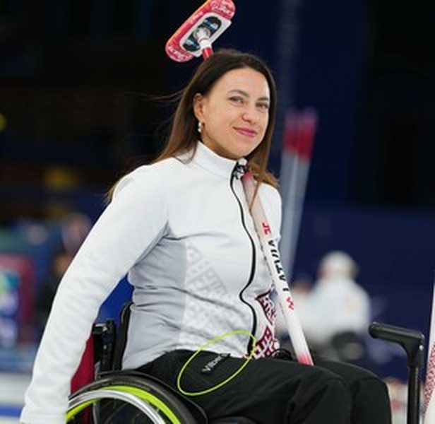Een rolstoelcurlingsporter in kleding van Vilber's