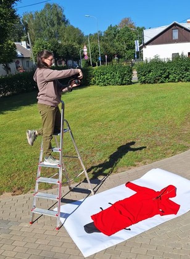 Een rode regenjas uitgelegd tijdens een fotoshoot